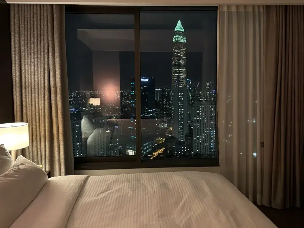 24/7 Massage in Bangkok: Are Late-Night Services Really Worth It? A Bangkok hotel room at night with the city skyline glowing through the window