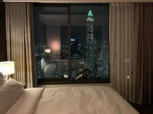 Divine Thai Spa A Bangkok hotel room at night with the city skyline glowing through the window