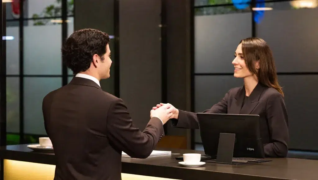 Massage at the Hotel: What to Say at the Front Desk A hotel guest politely speaking with a receptionist at a hotel front desk